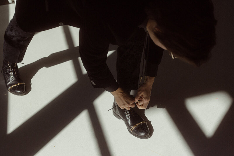 A person leaning down tying their shoe.