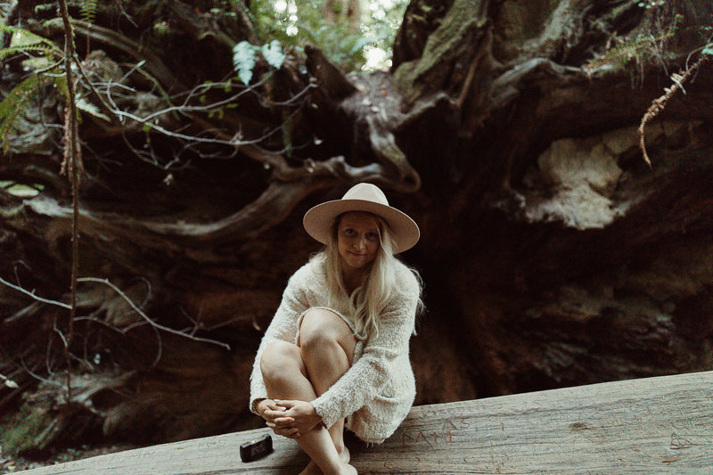 girl sitting on log in Redwoods National Park