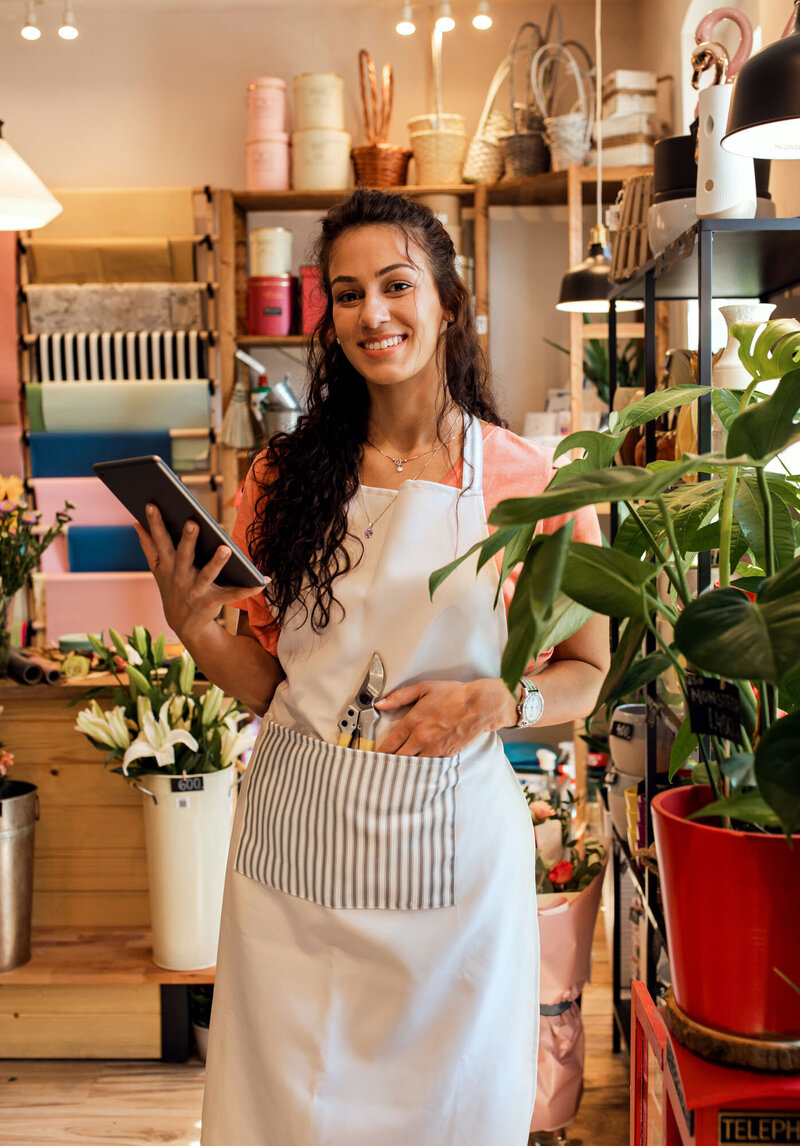 Business woman wearing apron and holding a tablet