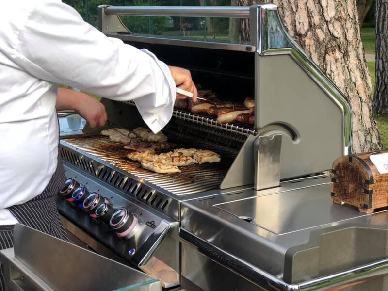 Koch grillt verschiedenes Fleisch auf dem Grill beim BBQ im Gartenrestaurant des Hotel Bernstein.