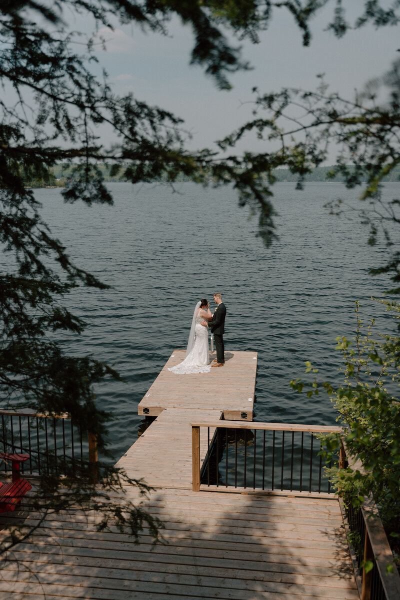 A wedding portrait of a couple in front of the lake after their lake wedding, captured by Longpine Photography.