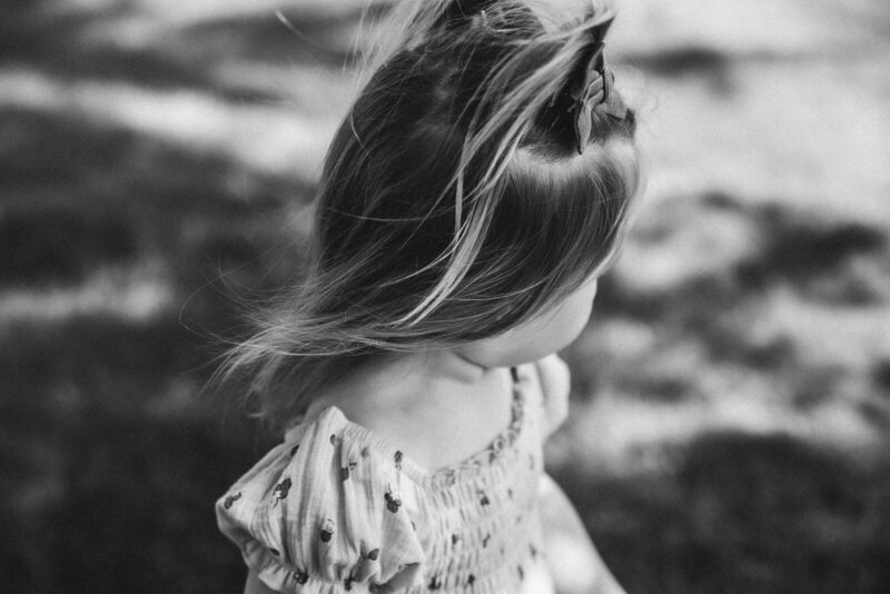 Black and white portrait of a child looking away from camera and hair blowing in the wind in Farmington, Missouri. 