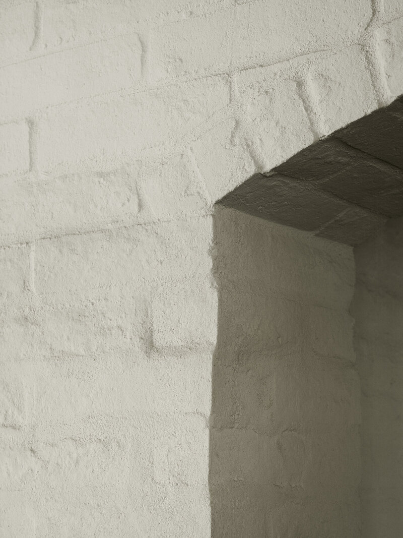 View showcasing artwork against concrete boardformed concrete and a view of the dining room designed by Palm Springs architect