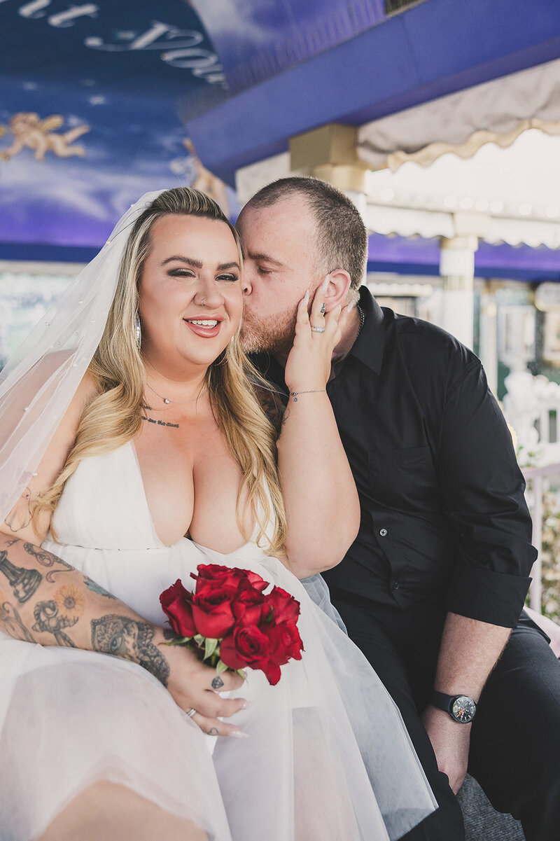 bride embraces groom after elopement outside little white chapel in las vegas