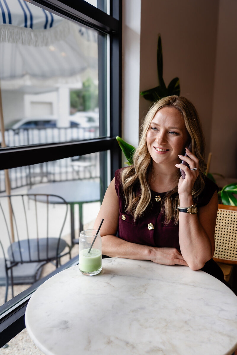 Woman working on iphone at a table, representing Fresh Page Marketing’s ecommerce management, copywriting, and website design services for small businesses