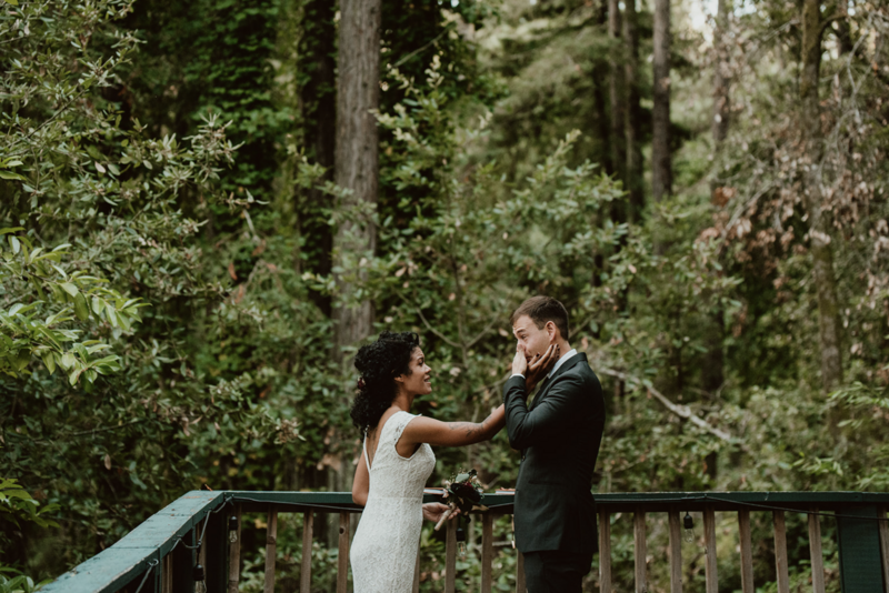 Bride caressing her partner's face as he wipes away tears during their redwood forest elopement ceremony in Sonoma County