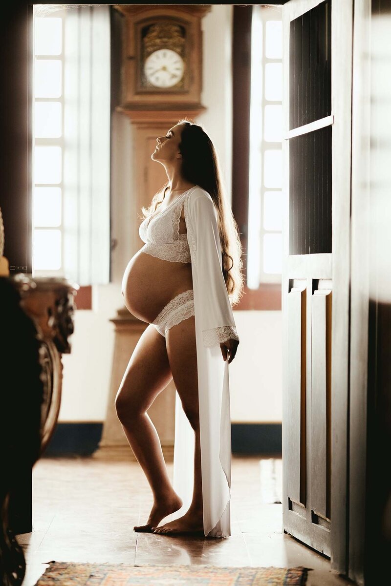 Femme enceinte se tenant debout dans un salon