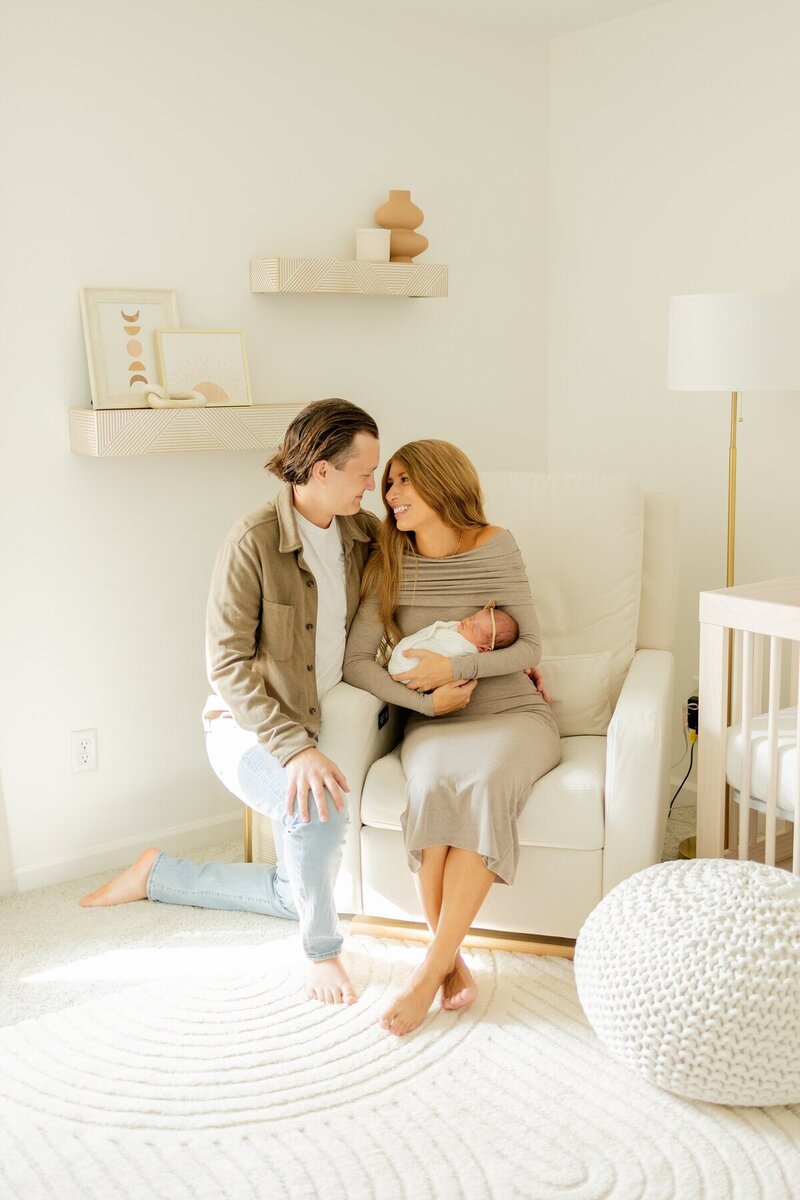 New parents holding their newborn in their nursery, taken by minneapolis newborn photographer