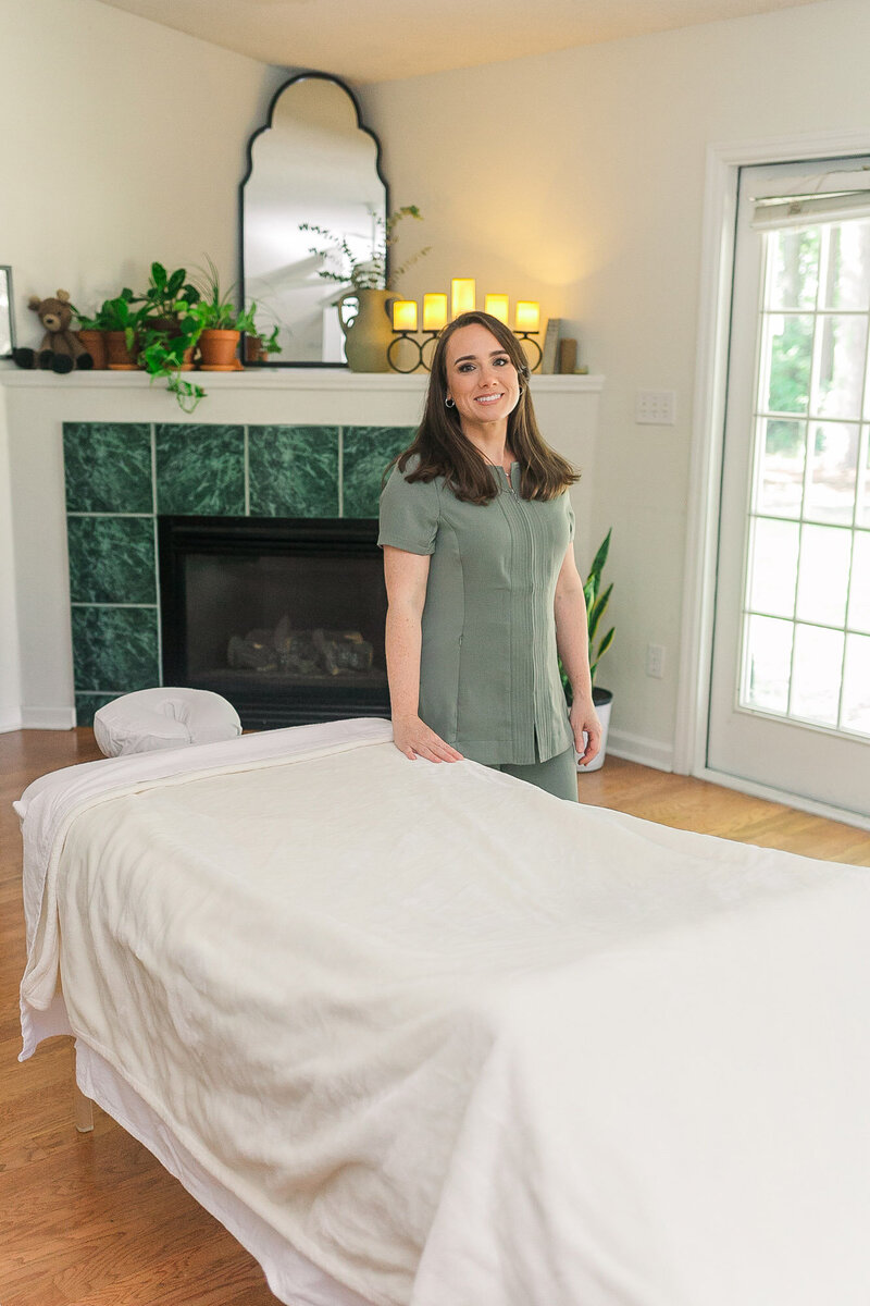Candice standing next to an empty massage table