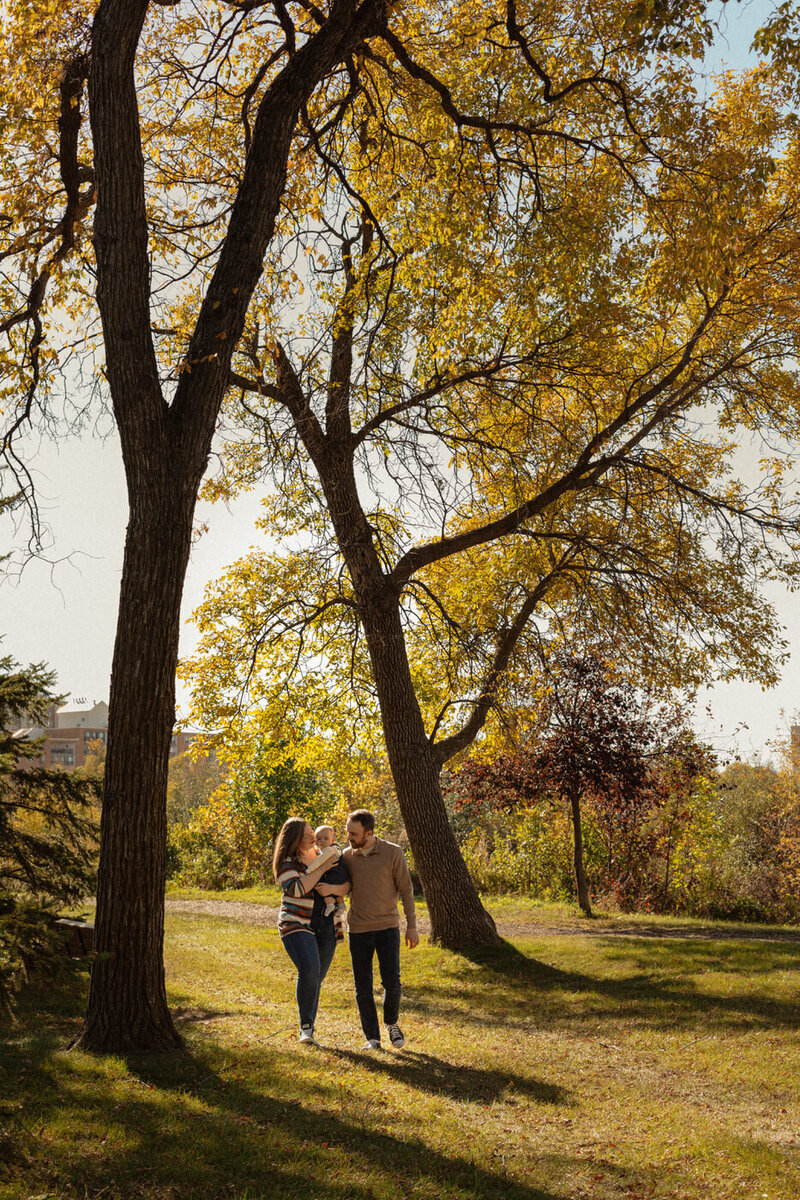 fall family photos in Winnipeg parents holding son walking 