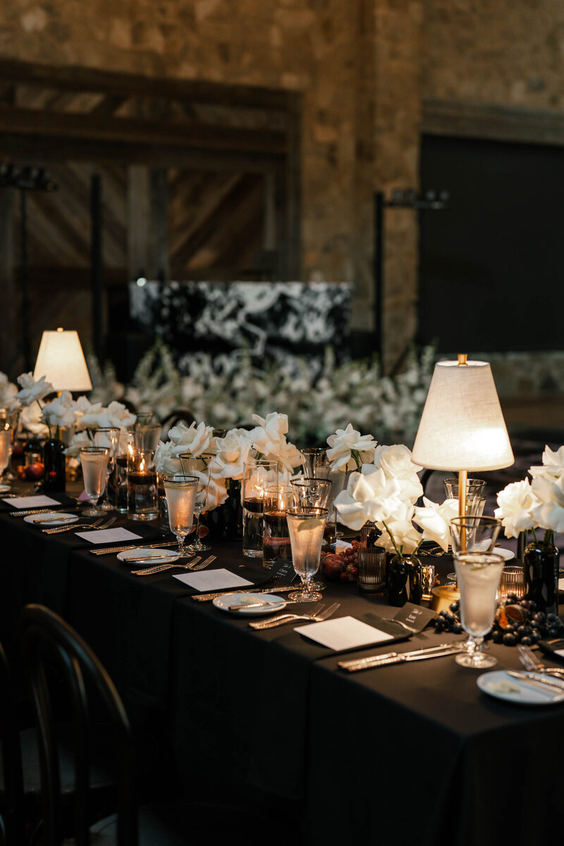 A long table set with place settings and lamps