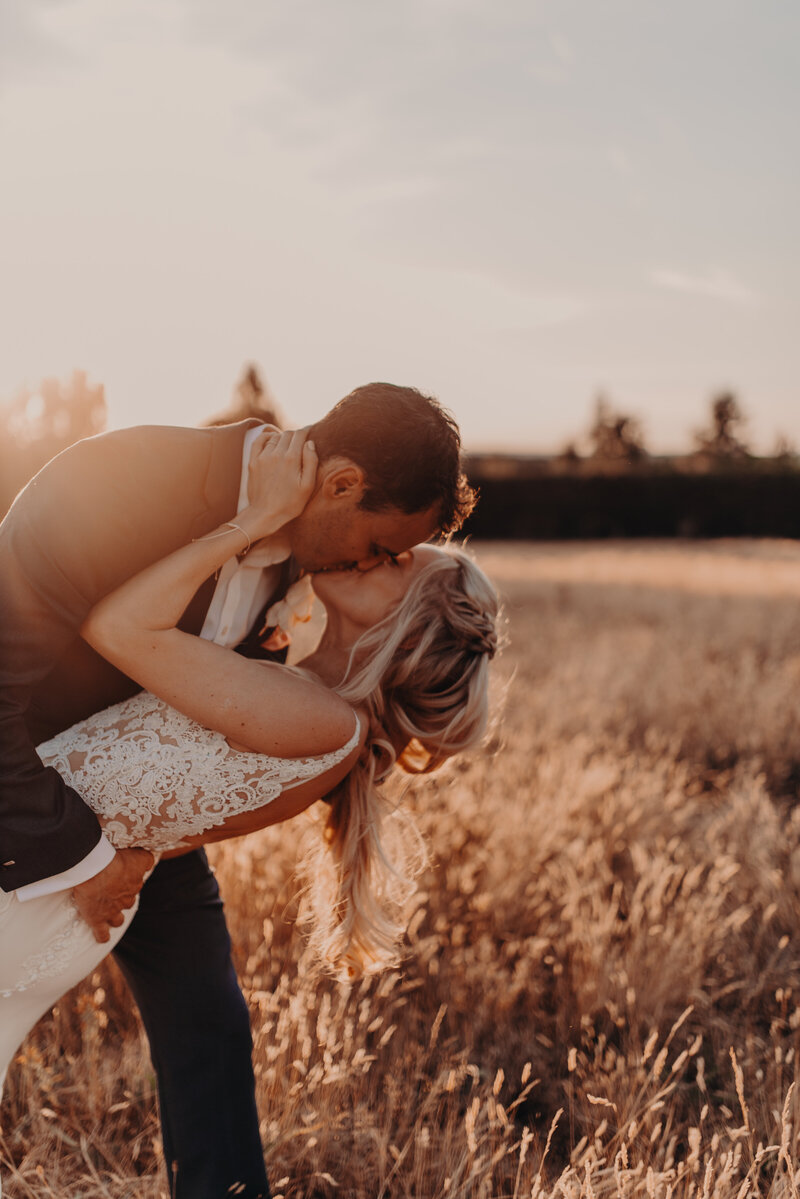 Parents, mother and father kissing and hugging there newborn on a summers day in Surrey