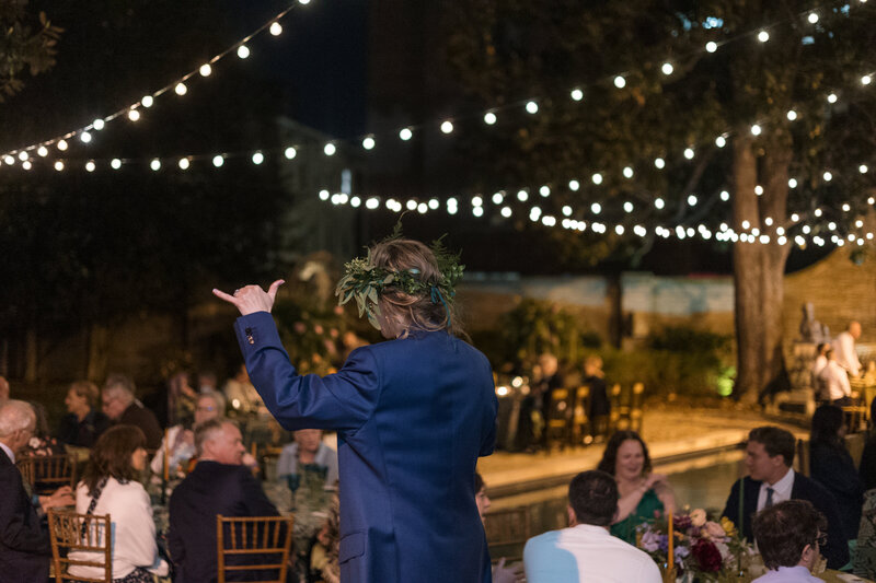 Bride having a great time at her wedding under café lights at dinner reception