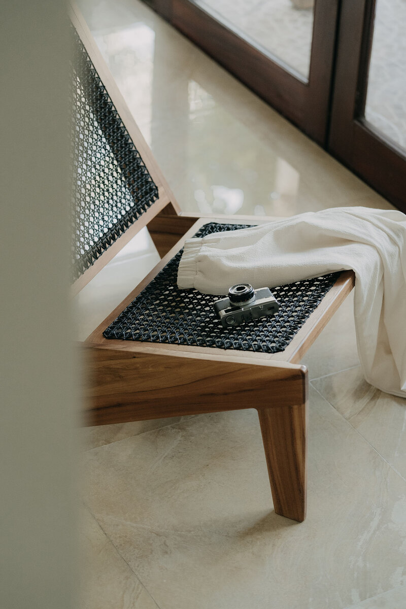 houten stoel naar Scnadinavisch ontwerp op een strakke marmeren vloertegel