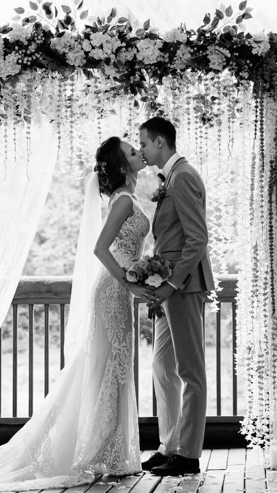 A bride holdes her bouquet over her shoulder in an artful bridal portrait.