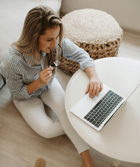 A woman who is sitting down and looking at her computer