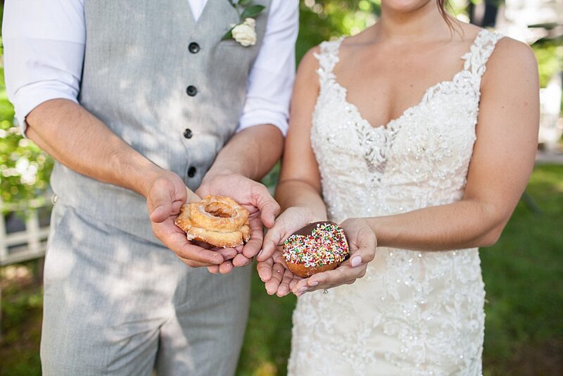 Bride and groom holding sprinkle cupcakes at reception