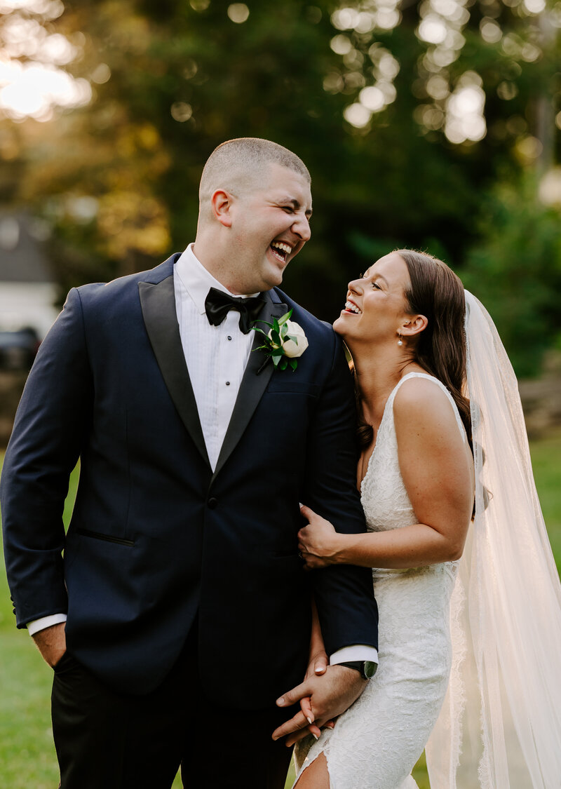 Bride and groom giggle at each other during portraits in Massachusetts