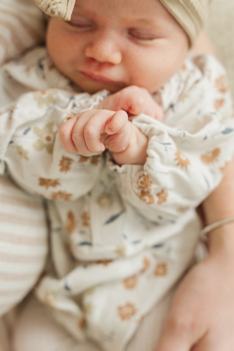 details of newborn baby in parents arms