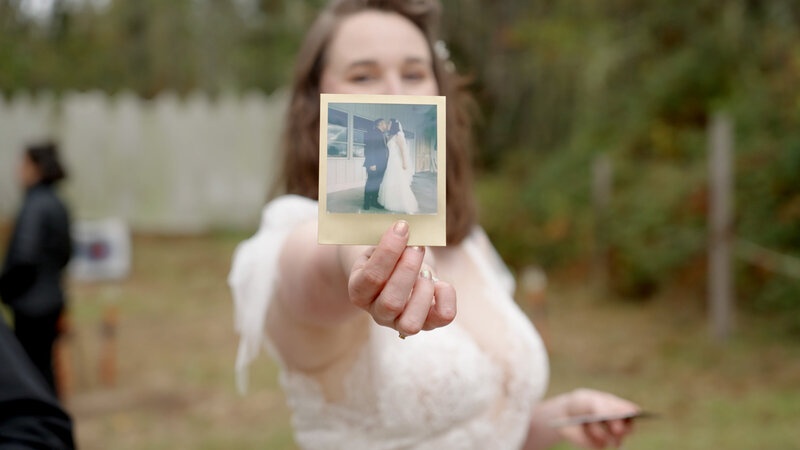 bride holding up a polaroid image