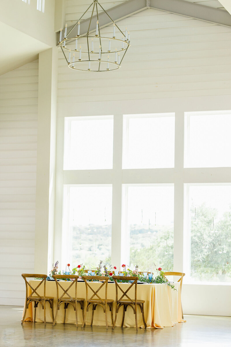 Tablescape and chairs set up in a white room with large windows