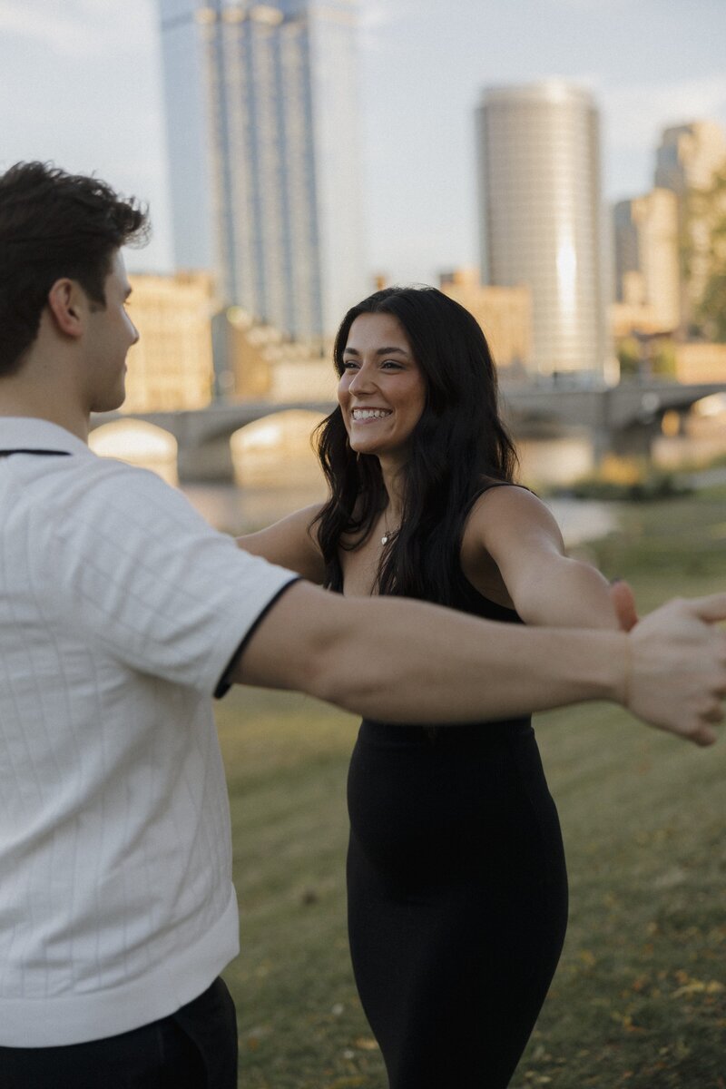 couple hold hands looking at one another