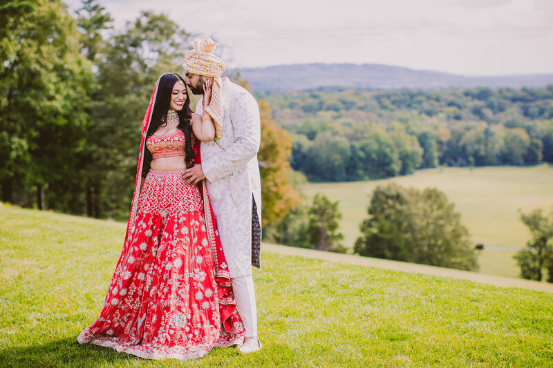 Pakistani Bengali wedding bride and groom with a red dupatta over their heads before their muslim ceremony