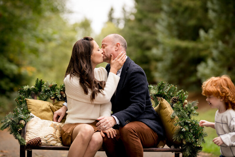 Parents enjoy a kiss during a holiday photoshoot in the Seattle area.