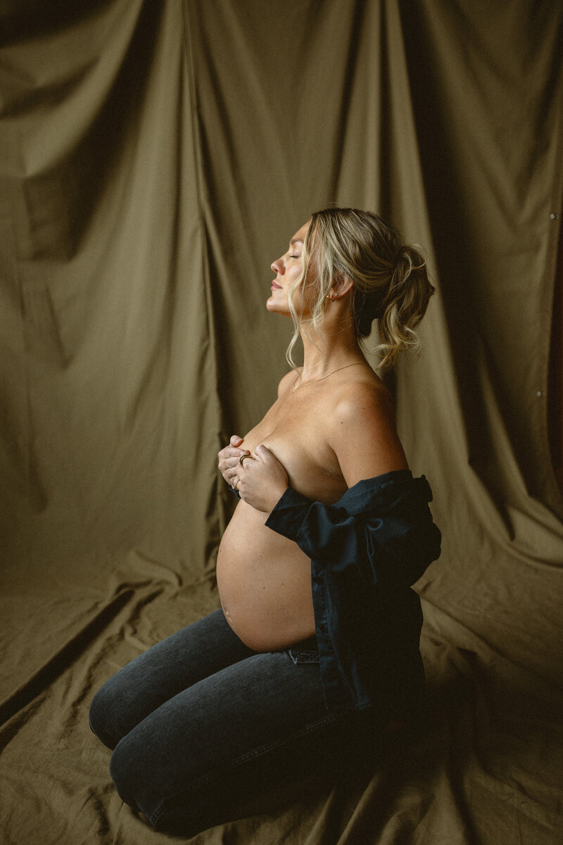 Pregnant mother's belly wearing an orange silk dress.