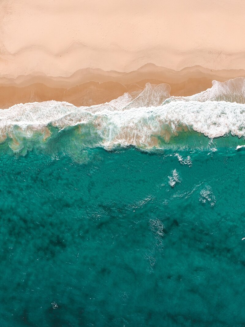 Vue aérienne d'une plage : océan bleu et sable fin