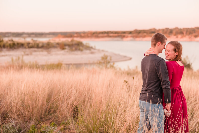 Couple embrace on top of the mountain during their engagement session at Garner State Park in Concan, Texas. Photo taken by Austin Engagement Photographers, Joanna & Brett Photography