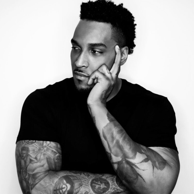 black and white personal branding headshot Joe Barksdale resting chin in hand tattoos showing