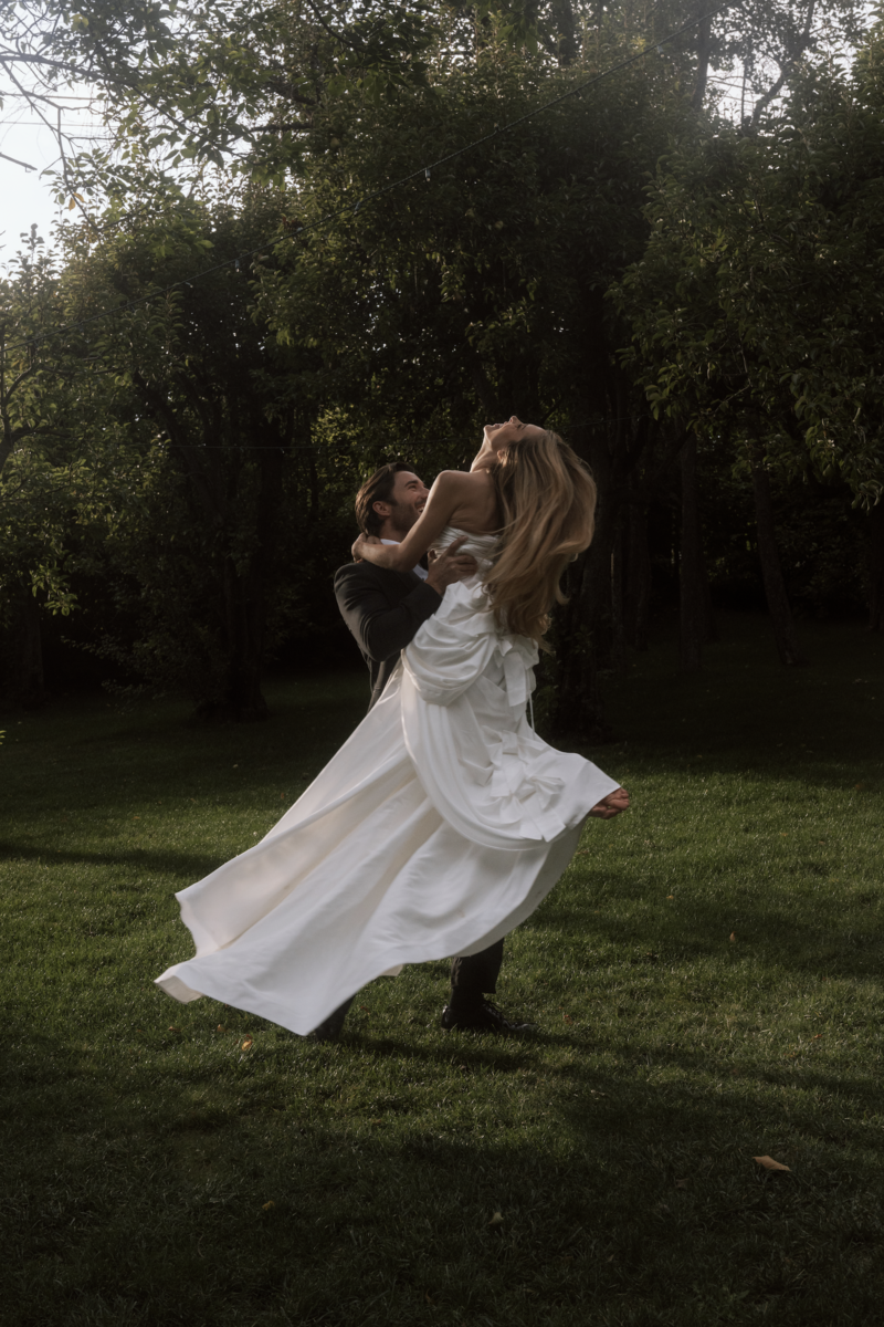 Bridal couple running through vineyard