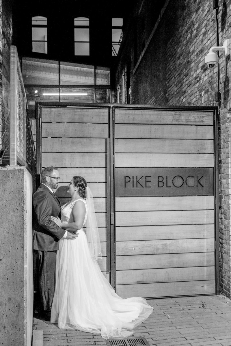 Bride and groom posing in front of a Pike Block sign