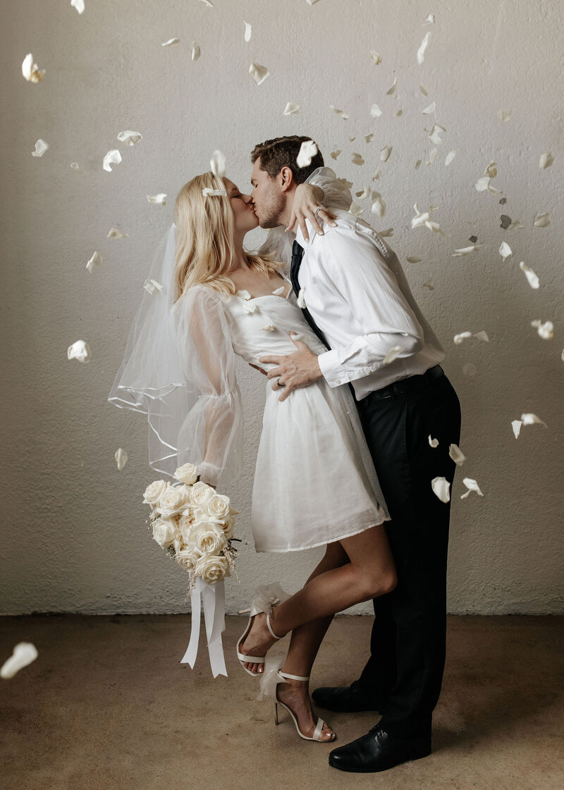 flowers falling around a couple kissing