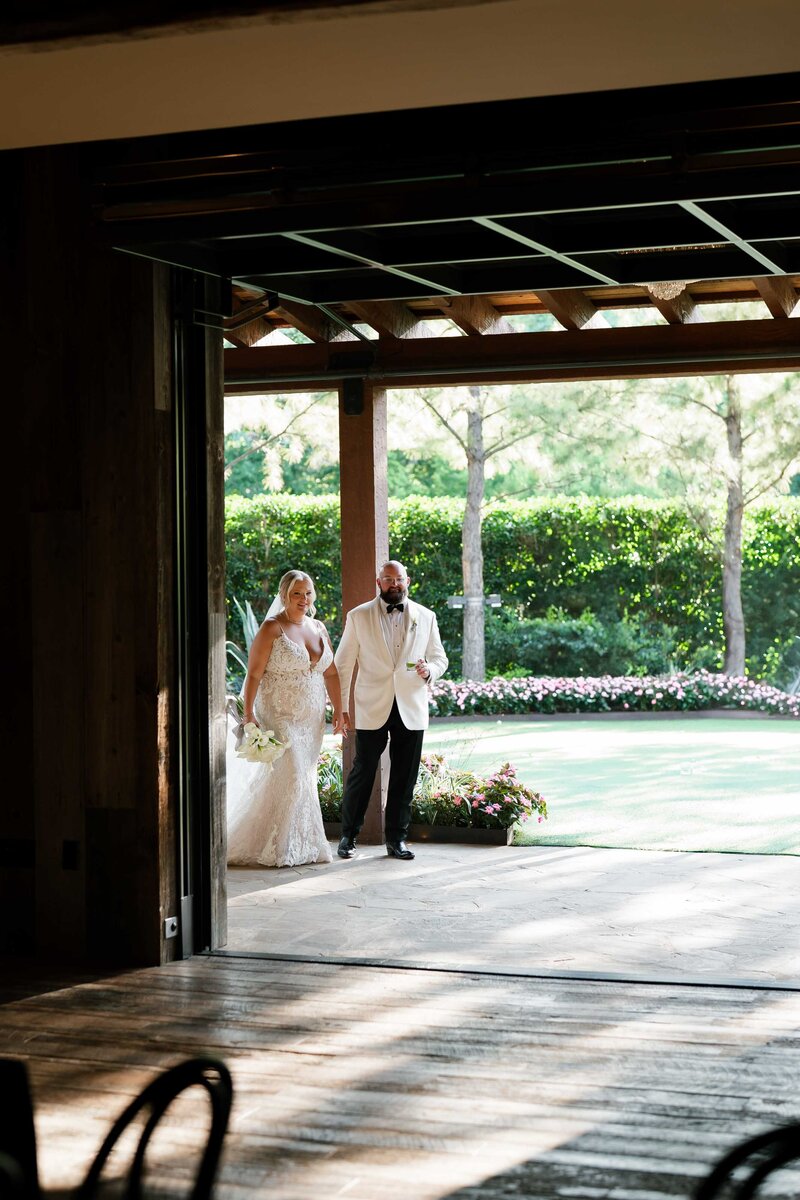 A bride and groom seen through a door way