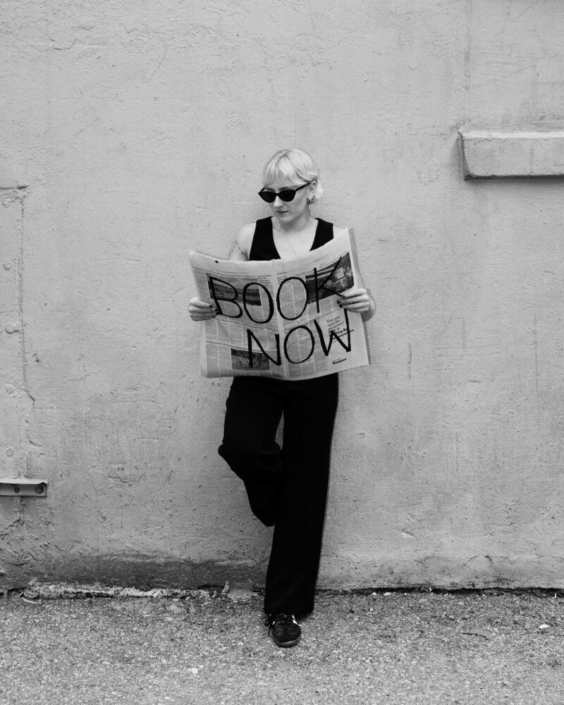 Hairstylist Hannah Hewitt holding a book now paper.