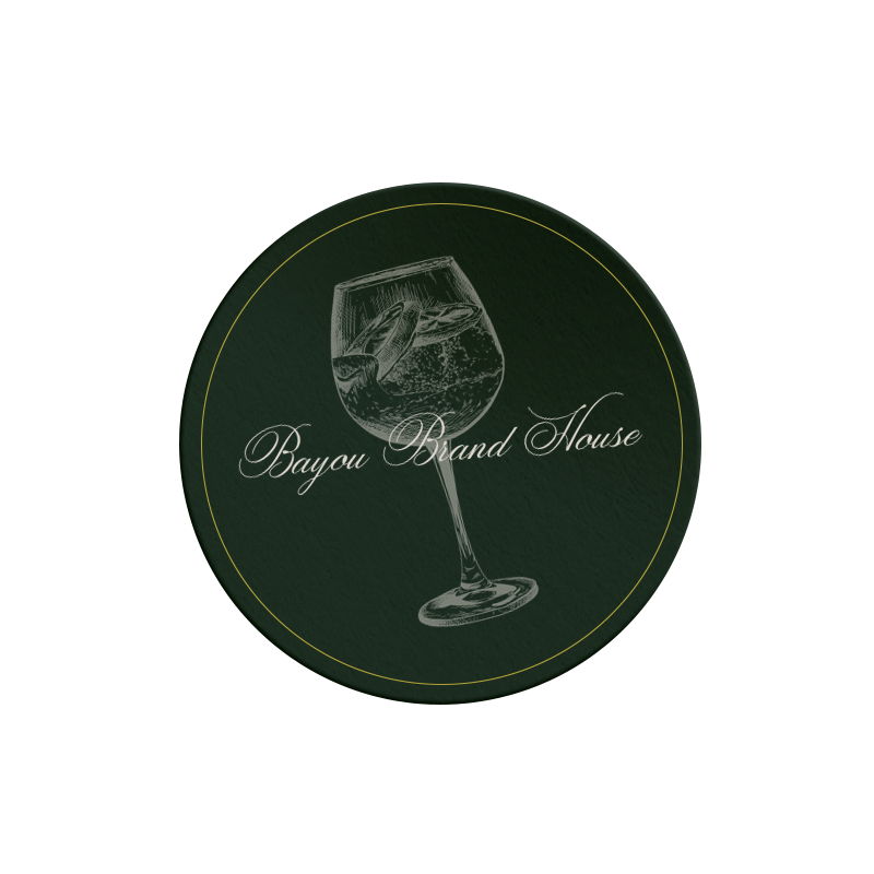 A dark green coaster featuring an illustration of a wine glass with a fish inside it and the text "Bayou Brand House" written in elegant script, perfect for your small business website design services.