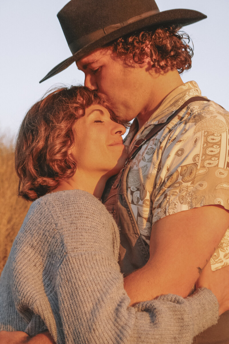 couple kissing at golden hour in ocean beach, san francisco by oceanside based engagement photographer