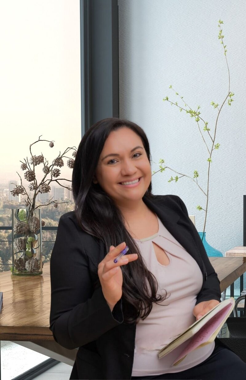Ana smiles as she holds a pen and notebook in hand. Contact us to learn more about our relationship assessment, couples assessment, and other services.