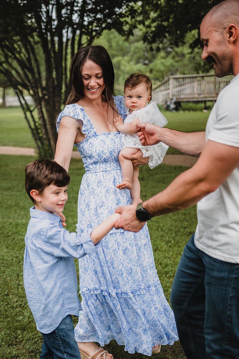 Family playing ring around the rosie during lifestyle session in New Braunfels, TX.