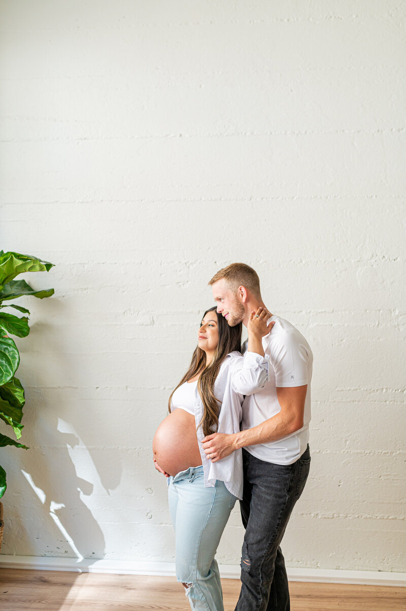 A couple who is expecting their first child posing for a maternity session in studio in downtown Lewiston, Idaho