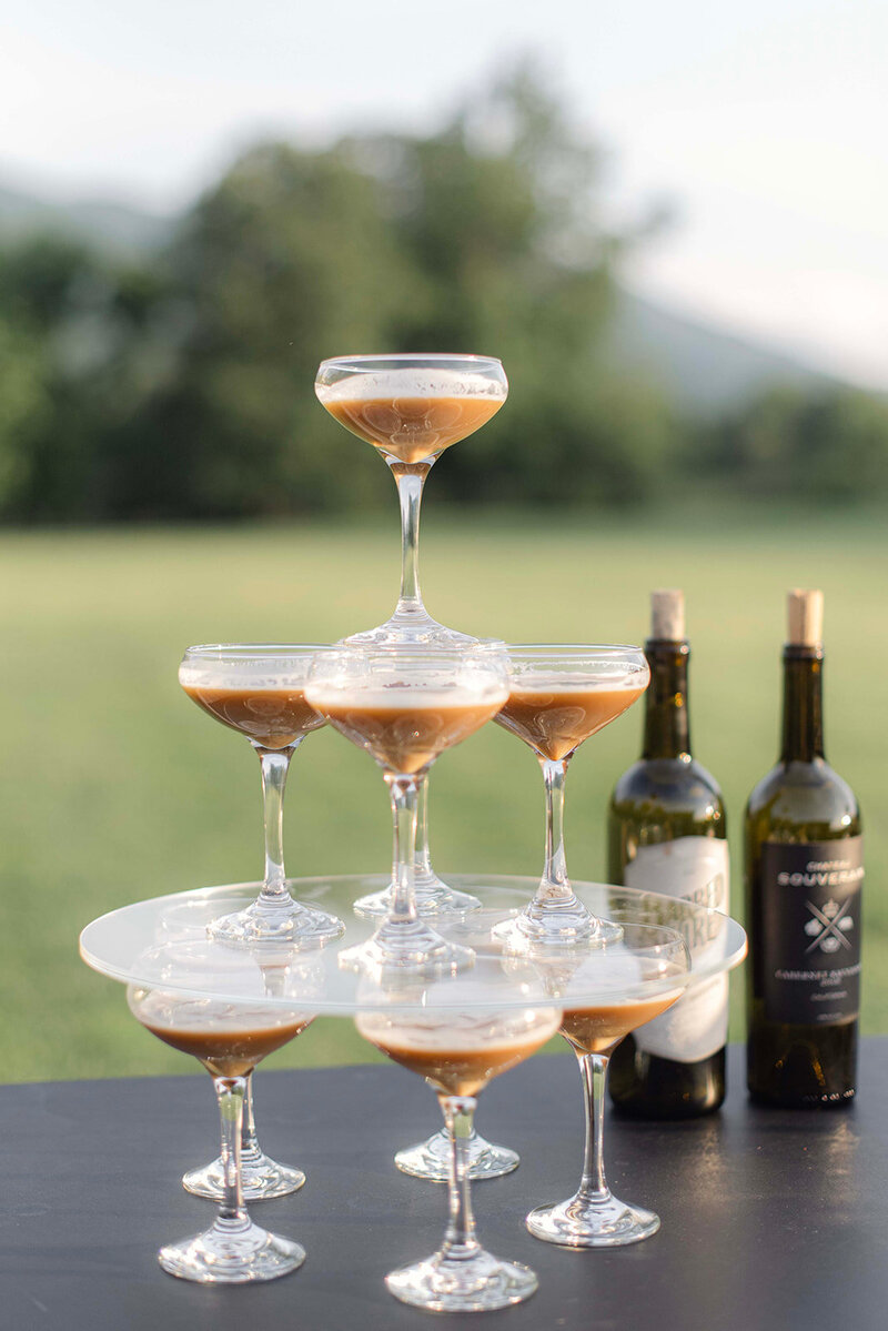 Martini glasses filled with a dessert drink stacked in a pyramid tower