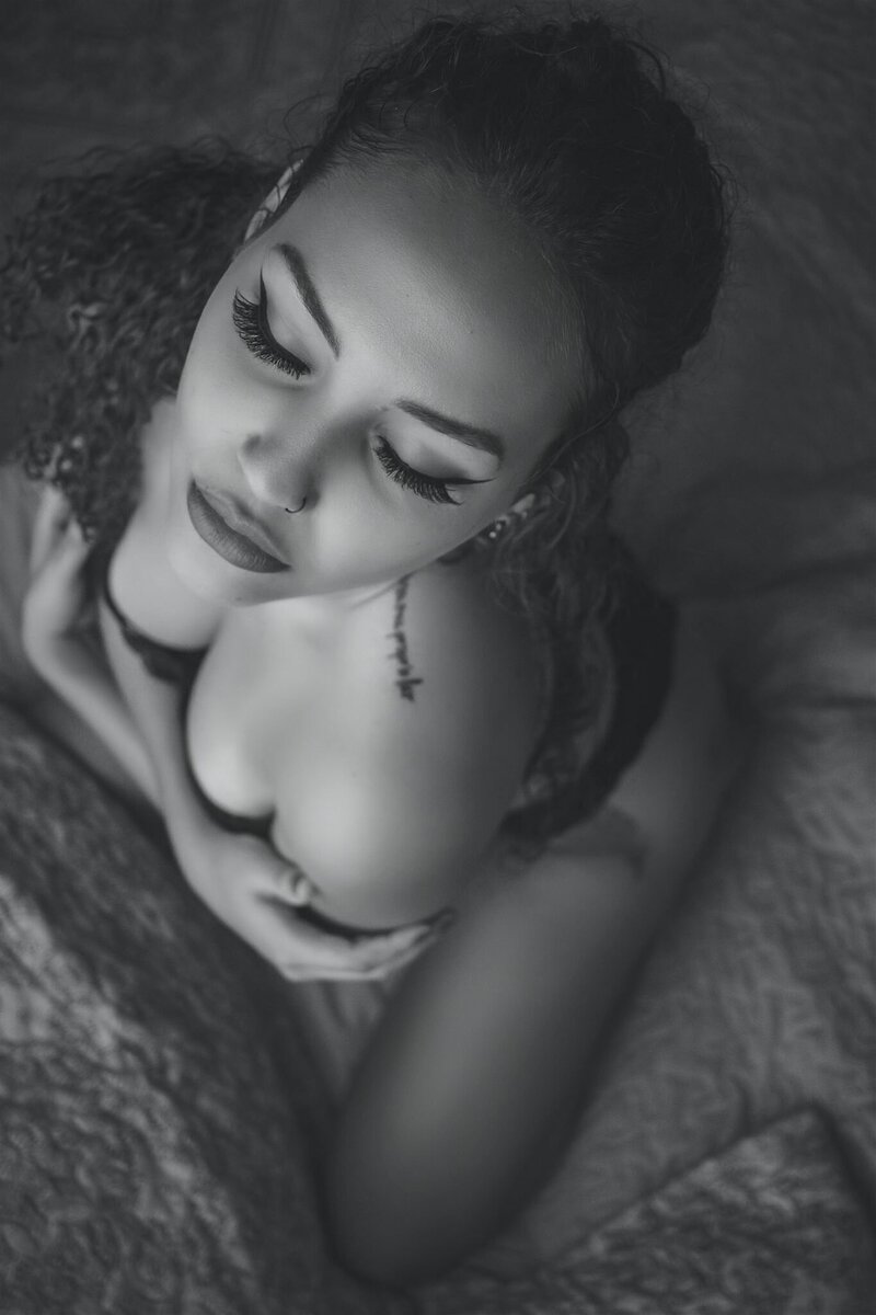 boudoir photo ideas with woman in a black set with her arms wrapped around herself captured by Baltimore photographers