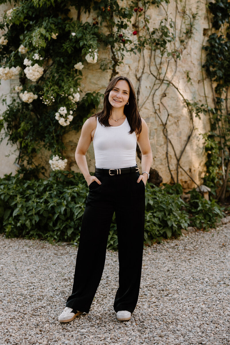 A person with their hands in their pocket smiling 