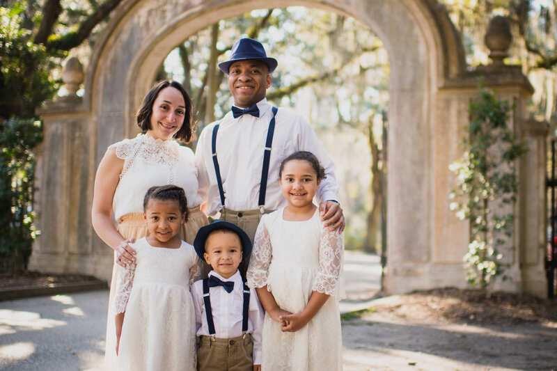 Family standing in front of entrance to Wormsloe Historic Site in Savannah, GA. Savannah GA photographer.