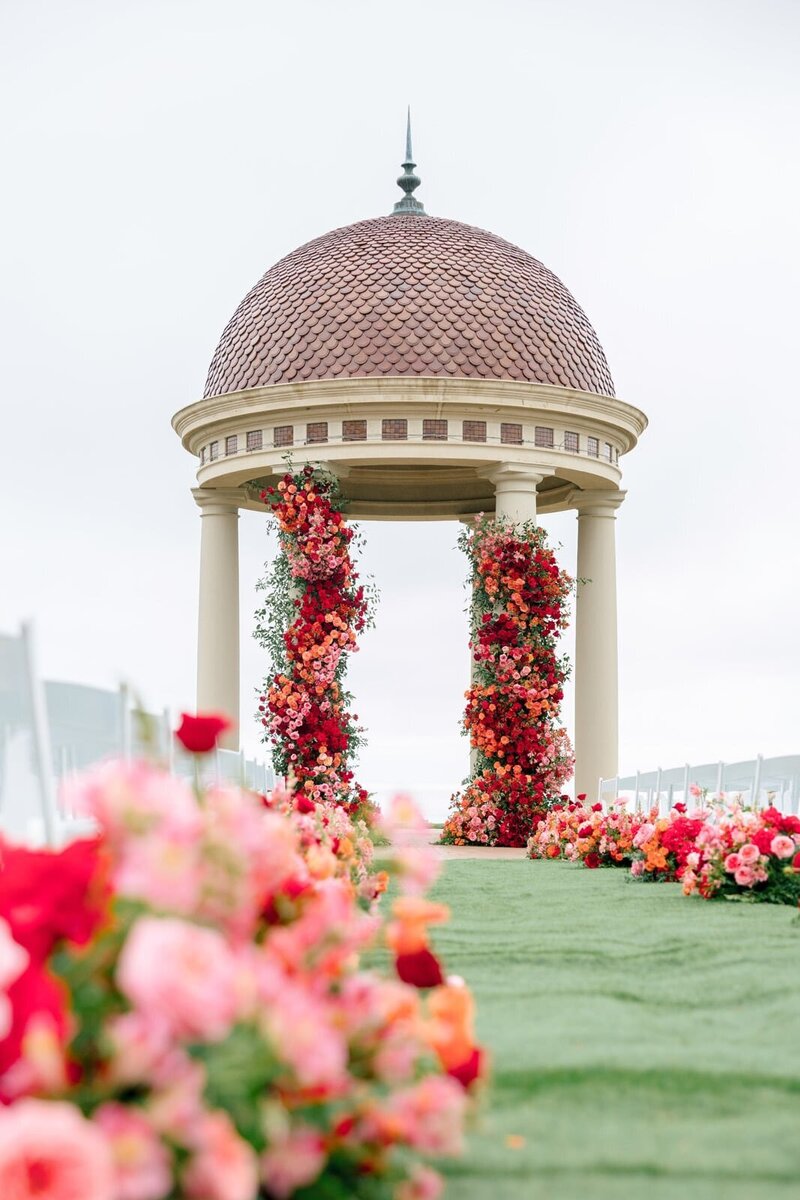 Pelican Hill rotunda decorated with beautiful red, pink, and peach flowers