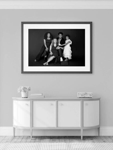 Elegant black and white family portrait framed on a wall.