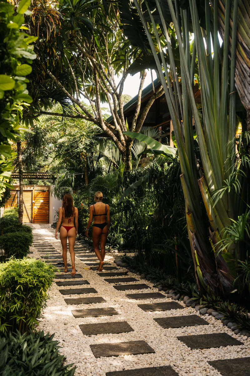 Two girls walking down lush greenery