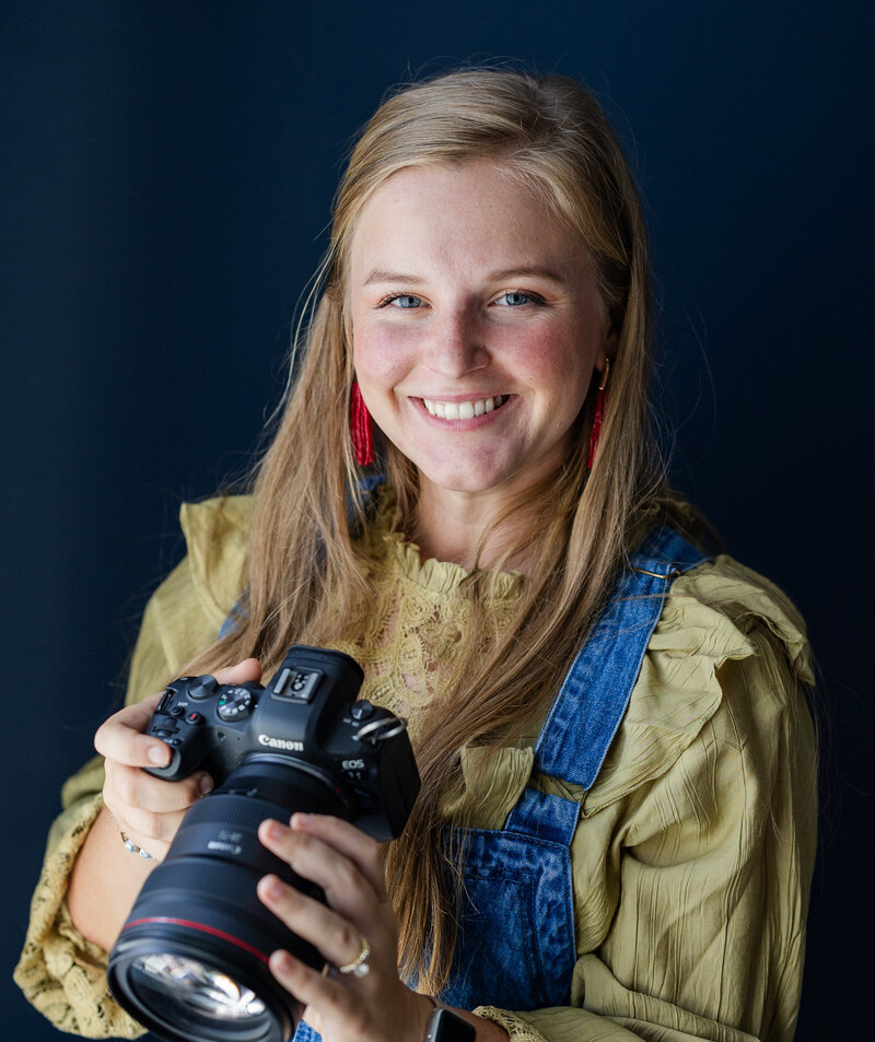 Nicole smiling while holding a camera